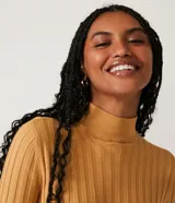 Polera color camel de punto acanalado, con cuello alto y mangas largas.