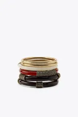 Set de cinco pulseras rígidas para mujer, que incluyen dos pulseras metálicas doradas y tres pulseras de resina en color blanco, rojo y marrón, con apliques metálicos labrados.