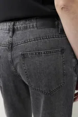 Pantalón jean gris oscuro de corte recto, tiro alto y calce relajado. Presenta apliques metálicos en los laterales.