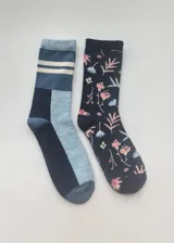 Pack de dos pares de medias de media caña con diseños diferentes. Un par es de color azul con bloques de color y rayas horizontales. El otro par es de color azul oscuro con estampado de flores y hojas en tonos rosa y celeste.