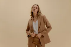 Blazer blanco de corte entallado, con solapas, cierre de un botón y bolsillos con tapa. Confeccionado en tela de sastrería noble.