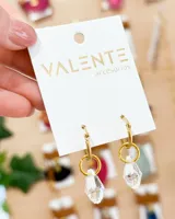 Aros colgantes dorados con dije de cristal facetado transparente.