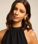 Vestido corto negro con escote halter y volados superpuestos en la falda.