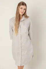 Vestido camisero corto de lino color celeste, con cuello clásico, cierre frontal con botones, mangas 3/4 con trabillas y bolsillo de parche en el pecho con bordado de iniciales.