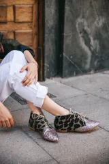 Botines acordonados con estampado animal print y puntera cubierta de glitter plateado.