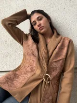 Chaqueta marrón con mangas largas, solapa ancha y cinturón con hebilla.