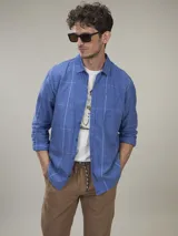 Camisa celeste a cuadros blancos, de manga larga y corte recto.