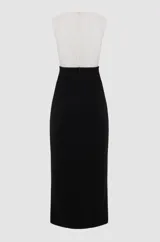 Vestido midi negro y blanco, sin mangas, con top blanco drapeado con bordados florales de tul con perlas y cuentas de vidrio doradas, falda negra con tajo lateral y corte ajustado.
