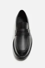 Mocasín de vestir negro con detalle de antifaz en el empeine y suela a tono con ligero tacón.