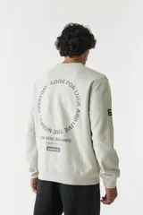 Buzo verde oliva de felpa con cuello redondo, puños y cintura acanalados. Estampado frontal con la frase "The Real Balance" en letras blancas y logo de la marca Mistral.