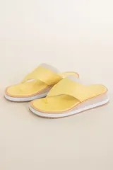 Sandalias de cuero color amarillo, con plataforma de madera y suela de goma.