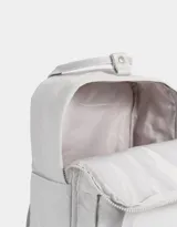 Mochila negra de tela deportiva con correas regulables, manijas superiores con broche, acceso con cierre superior y puller de cuerina, bolsillo frontal con cierre y puller de cuerina, y tag de goma.