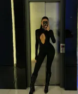 Catsuit negro de calce ajustado, con cuello alto, mangas largas y abertura en forma de gota en el pecho.