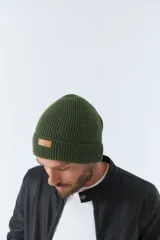 Gorro de lana azul marino con etiqueta de cuero con logo de la marca.