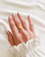 Anillo dorado de acero con diseño circular abierto.
