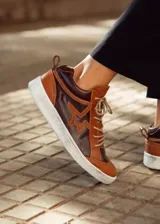 Zapatillas de cuero color beige con detalles en marrón y blanco. Aplique en forma de estrella en el lateral.