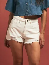 Short de jean blanco con roturas y terminaciones desflecadas.