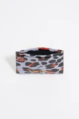 Tarjetero Bimba y Lola con estampado animal print en tonos lila, negro y naranja. Confeccionado en poliéster y poliuretano con logo metálico.