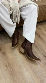 Bota texana corta color chocolate, de cuero, con punta fina y bordados decorativos en el empeine.