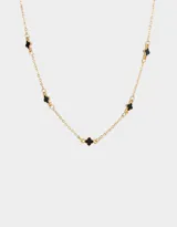 Collar corto dorado con cadena de eslabones y dijes de flores esmaltadas negras.