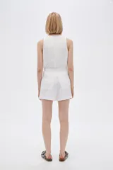 Short blanco de lino, de tiro alto y corte holgado.