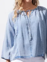 Blusa celeste de lyocell con cuello a la base y escote en V con lazo de ajuste. Manga larga amplia.