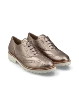 Zapato Oxford color bronce con detalles de perforaciones y suela blanca de goma.