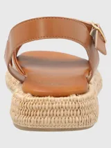 Sandalias Concetta de cuero color marrón claro, con tiras cruzadas y ajuste con hebilla en el tobillo. Plataforma con base tejida tipo esparto y plantilla acolchada.