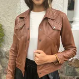 Campera marrón de cuero ovino con cuello clásico, cierre frontal con botones a presión, bolsillos con solapa en el pecho y mangas largas con puños abotonados.