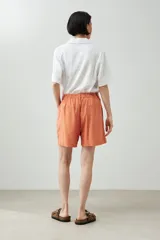 Short color durazno de lino con pinzas, tiro alto y bolsillos laterales.