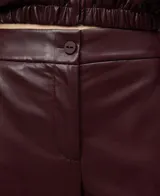 Pantalón culotte de mujer color bordó, confeccionado en viscosa con recubrimiento que simula piel. Presenta cierre frontal con botón, bolsillos laterales y bolsillos de vivo en la espalda. La pierna es ancha.