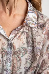 Camisa oversize de mangas largas con puños abotonados, cuello clásico y cierre frontal con botones. Estampado con motivos paisley en tonos pastel.