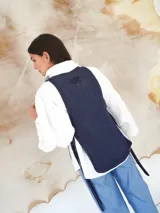 Chaleco de punto azul con escote en U pronunciado y laterales abiertos.