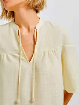 Blusa color amarillo claro de algodón con escote en V y mangas 3/4 acampanadas.
