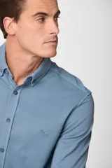 Camisa de pique de algodón de manga larga, color verde oscuro, con botones frontales.