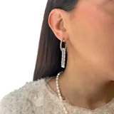 Aros colgantes de acero plateado con dije rectangular de circonias blancas.