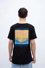 Remera negra de manga corta con cuello redondo y estampado fotográfico en la espalda con texto en la parte inferior.