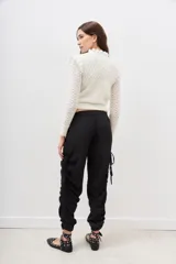 Pantalón jogger negro de nylon con elástico ancho en la cintura, puños elásticos ajustables y lazos laterales para fruncir.