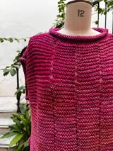 Chaleco negro tejido a mano en dos agujas con hilado 100% baby alpaca, ligeramente oversize, de hombros anchos y cuello tipo bote, con puntos calados en frente y espalda y tajos a los lados en el bajo.