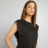 Camiseta negra sin mangas con hombreras marcadas y cuello redondo. Corte recto y holgado.