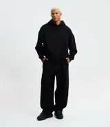 Pantalón baggy masculino color negro, confeccionado en algodón con felpa. Cuenta con cintura elástica con cordón ajustable, bolsillos delanteros y un bolsillo trasero aplicado. El bajo es ajustable con elástico.