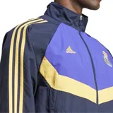 Campera de tejido técnico, color negro con detalles en morado y dorado, con escudo del Real Madrid bordado.