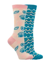 Par de calcetines largos de bambú con diseños asimétricos. Uno color crema con estampado de conchas en tonos celeste y rosa, y otro color celeste con estampado de ondas en blanco y rosa.
