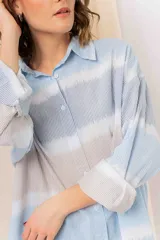 Camisa oversize de algodón liviano con estampado tie-dye a rayas en tonos pastel. Diseño suelto, manga larga con puños arremangados y botones frontales.
