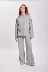 Sweater de punto color gris claro, de cuello alto y corte holgado.