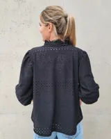 Blusa atemporal de color negro, con manga larga, cuello en V y diseño fresco.