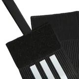 Banda de capitán Adidas Tiro League negra con tres tiras blancas y logo de la marca.