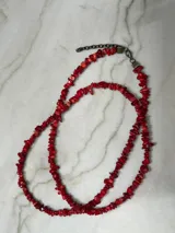 Collar largo de cuentas rojas y amarillas.