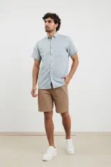 Camisa celeste de manga corta con cuello abotonado y bolsillo en el pecho.