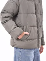 Campera puffer color gris topo, con cuello alto y cierre frontal.